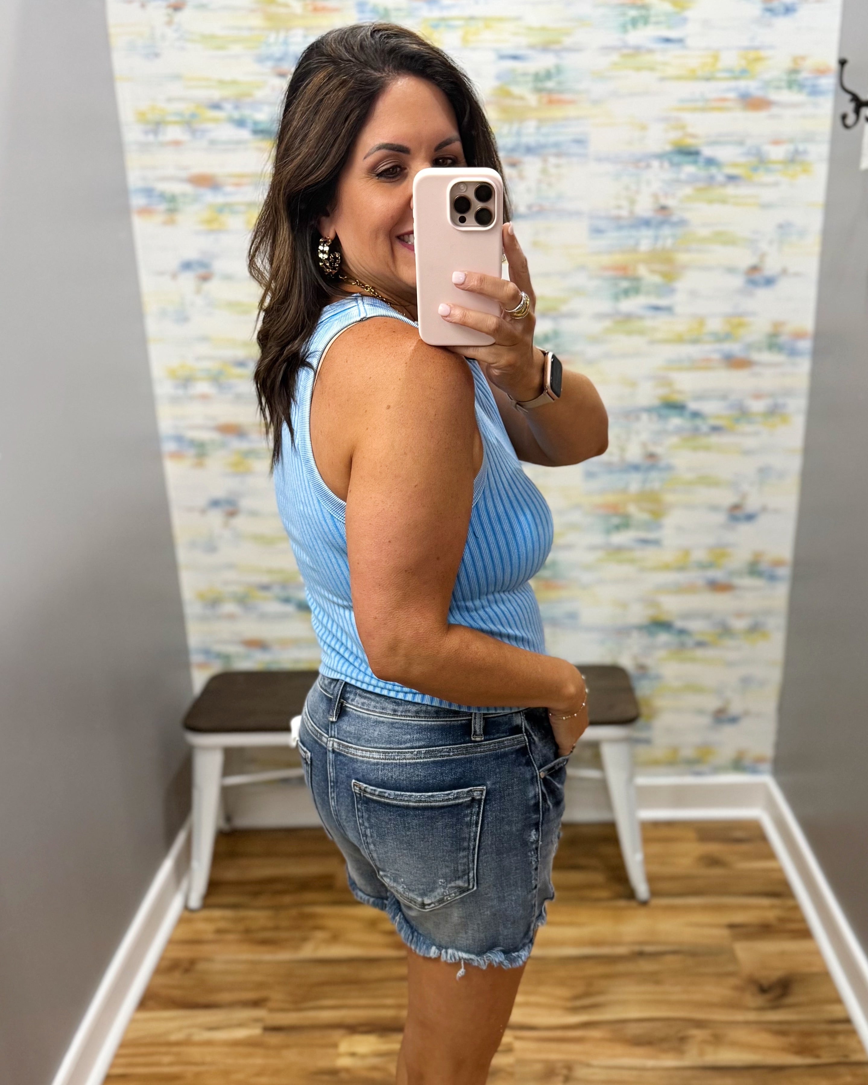 woman wearing sky blue tank with denim shorts.