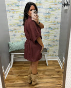 woman taking a selfie wearing a burgundy wrap dress featuring a V-neckline, cinched waist, and flowy short sleeves for a feminine silhouette.