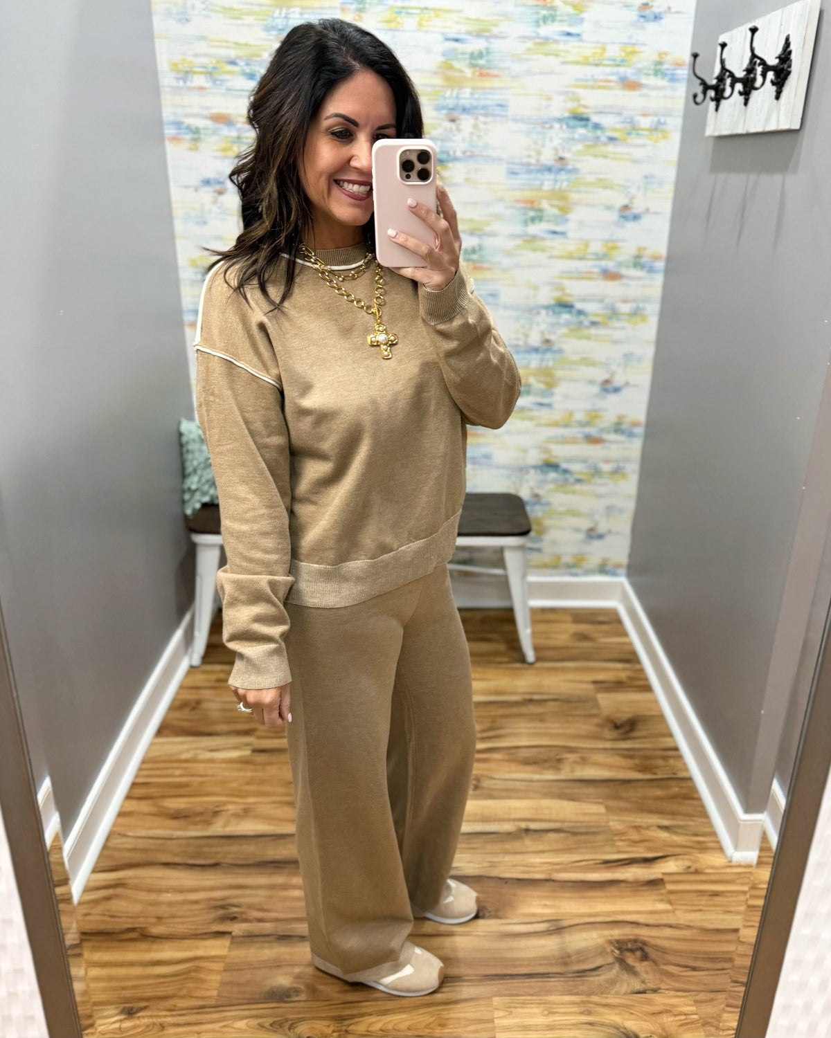 woman taking a selfie wearing a two-piece set in mocha with cream pipe stitching.  Set includes pants and long sleeve top.