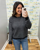 woman taking a selfie wearing a navy and white stripe sweater.