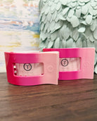 Pink and white product packaging on a wooden surface with a decorative background