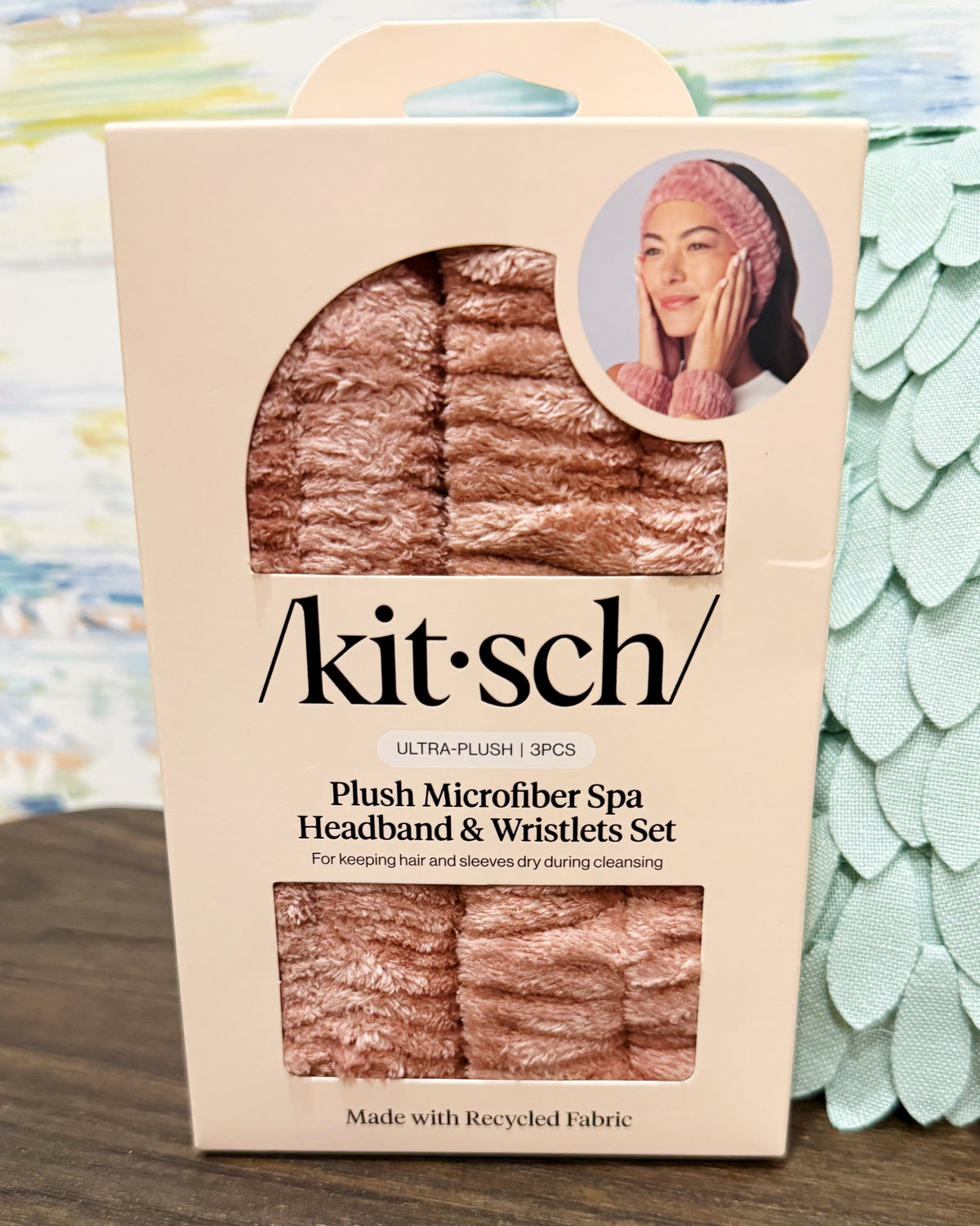 Kit Sch plush microfiber spa headband and wristlets set in its original packaging, featuring a rose gold color with a circular inset photo of a model wearing the headband.
