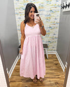 woman wearing gingham print dress in pink.