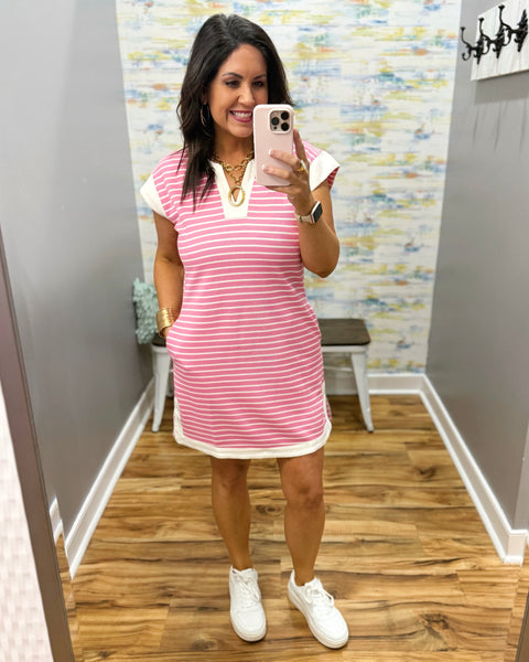 woman wearing pink and white stripe dress with white sneakers