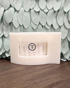 White electronic device with 'Teleties' branding on a wooden surface with a textured green wall background