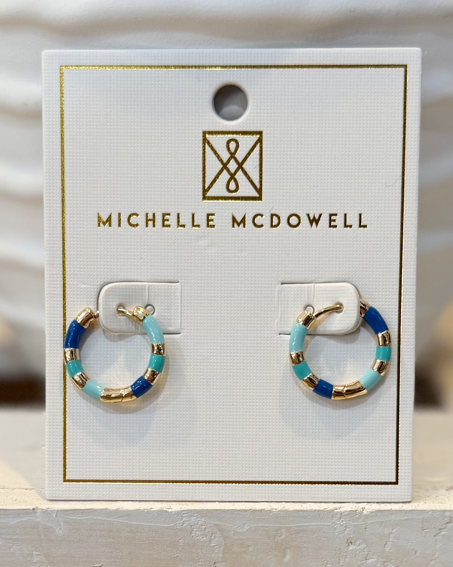 Pair of hoop earrings on a Michelle McDowell branded card.