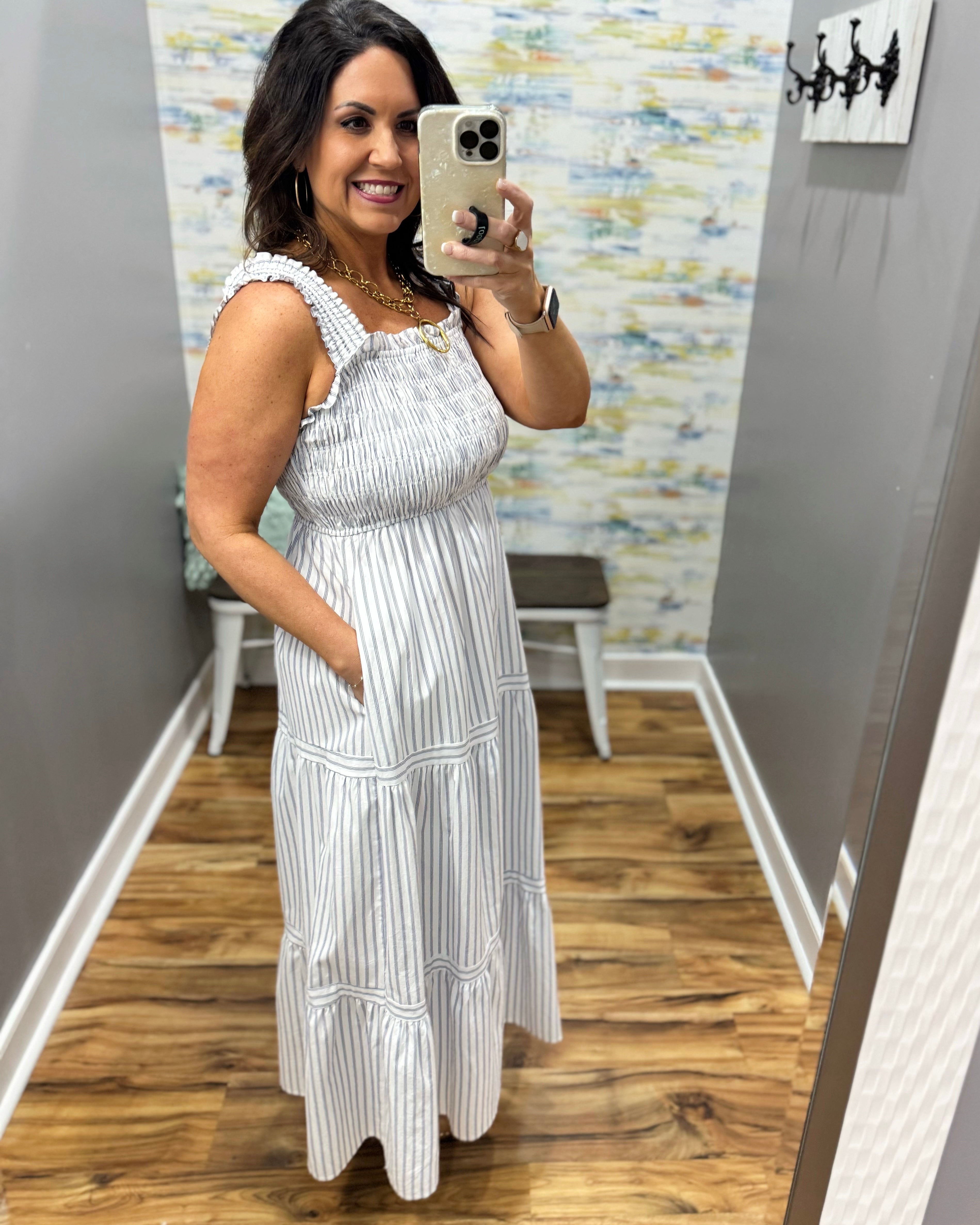 Woman wearing a white dress in a room with a textured wall.