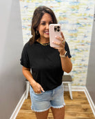 woman wearing black tee with denim shorts.