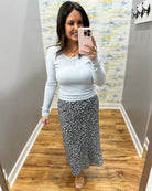 woman wearing navy floral midi skirt with light blue long sleeve top
