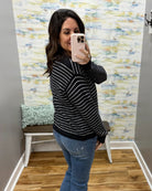 woman taking a selfie wearing a navy and white stripe sweater.