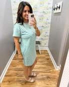 woman wearing a dark sage and white stripe dress.