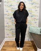 woman wearing a black scuba top and pants set.