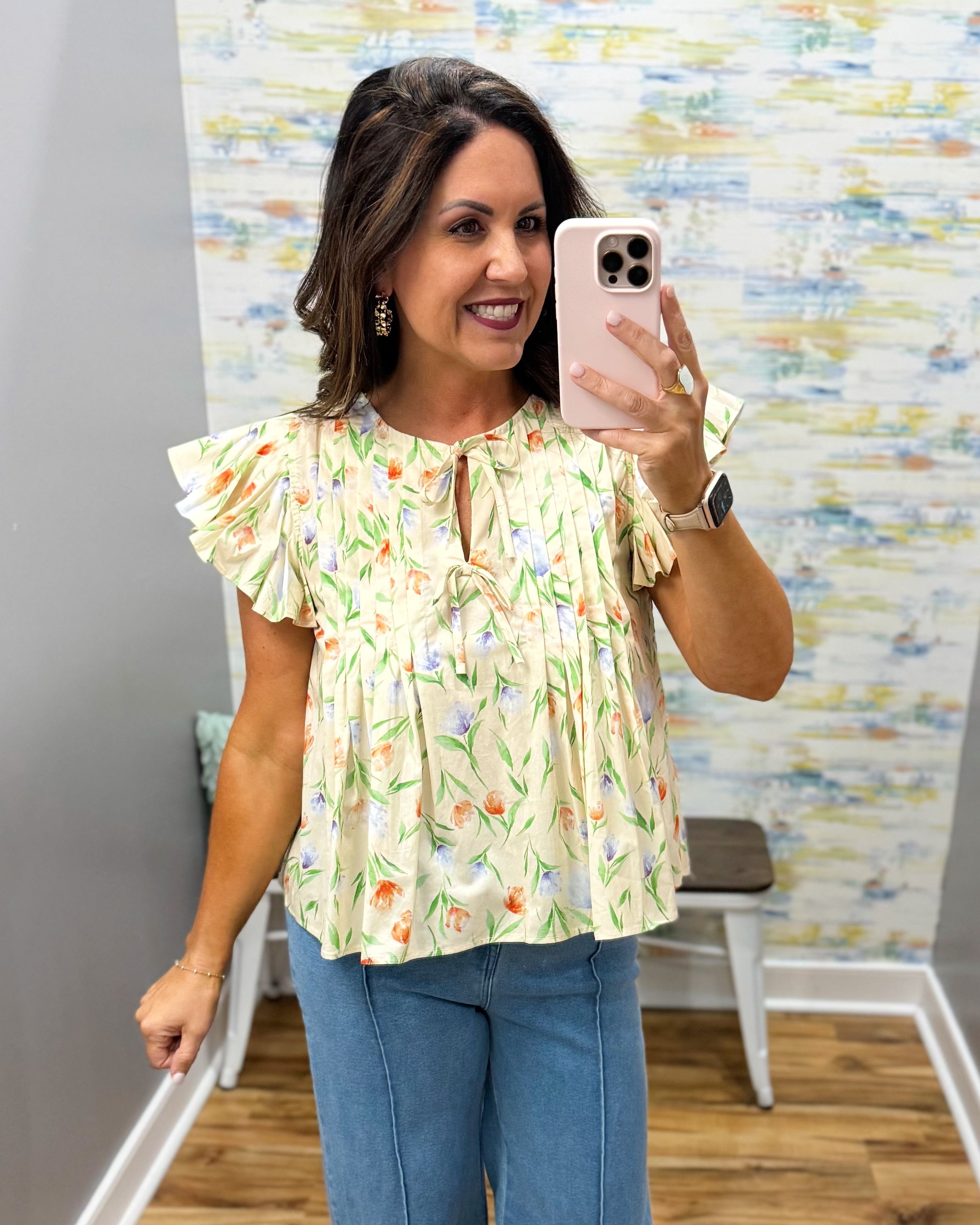 woman wearing a yellow floral blouse.