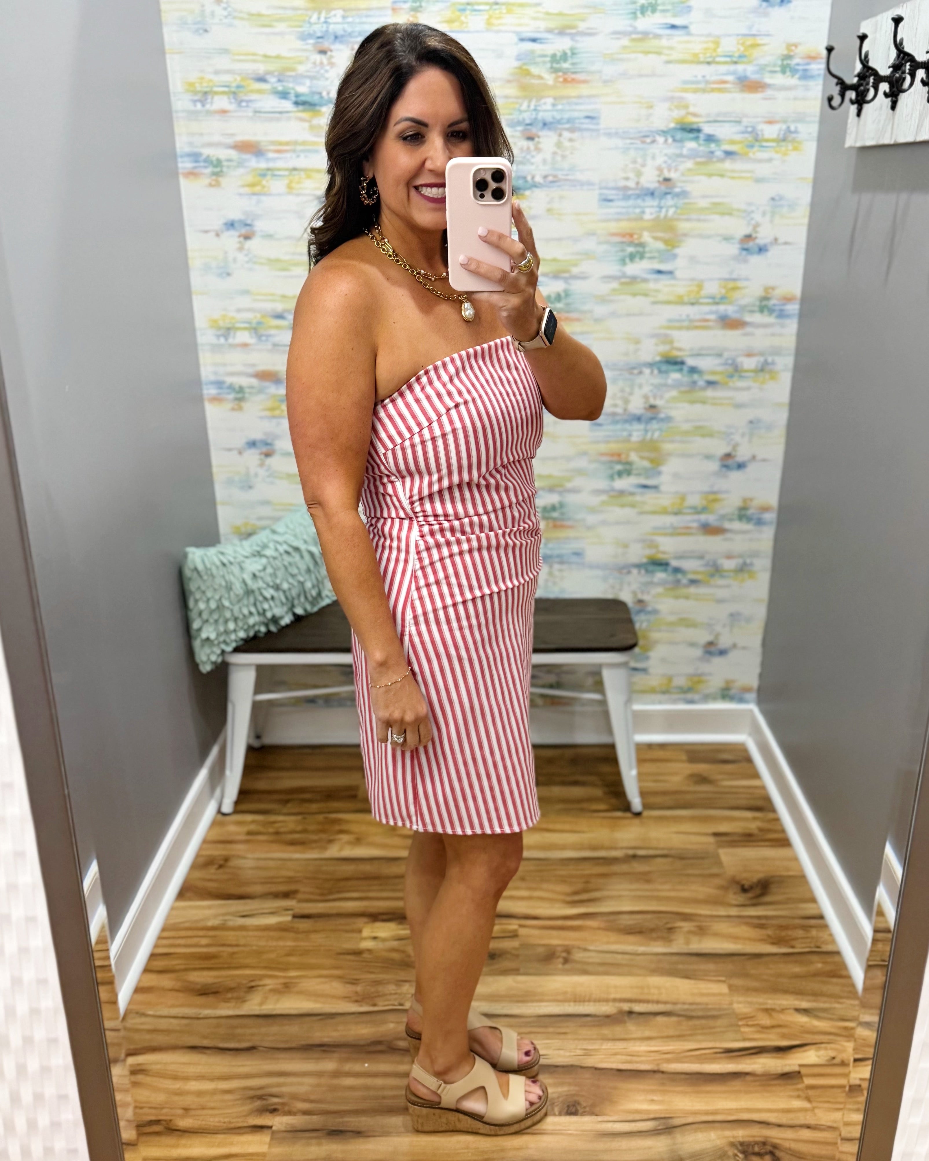 woman wearing a strapless red and white stripe dress.