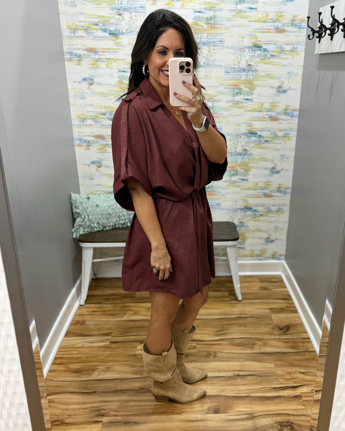 woman taking a selfie wearing a burgundy wrap dress featuring a V-neckline, cinched waist, and flowy short sleeves for a feminine silhouette.