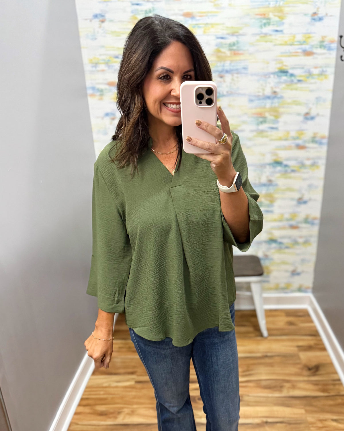 woman wearing a olive 3/4 sleeve flowy top.