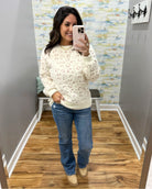 woman taking a selfie wearing a super soft cream sweater with subtle leopard print design. 