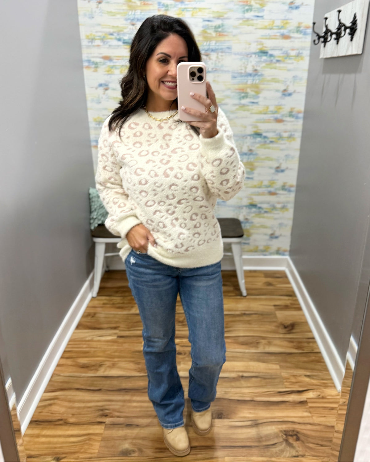 woman taking a selfie wearing a super soft cream sweater with subtle leopard print design. 