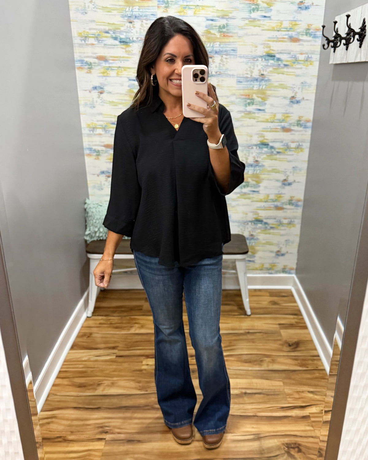woman wearing a black 3/4 sleeve flowy top with Judy Blue flare dark wash jeans and Corkys Pity Party wedge shoes.