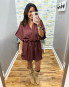 woman taking a selfie wearing a burgundy wrap dress featuring a V-neckline, cinched waist, and flowy short sleeves for a feminine silhouette.