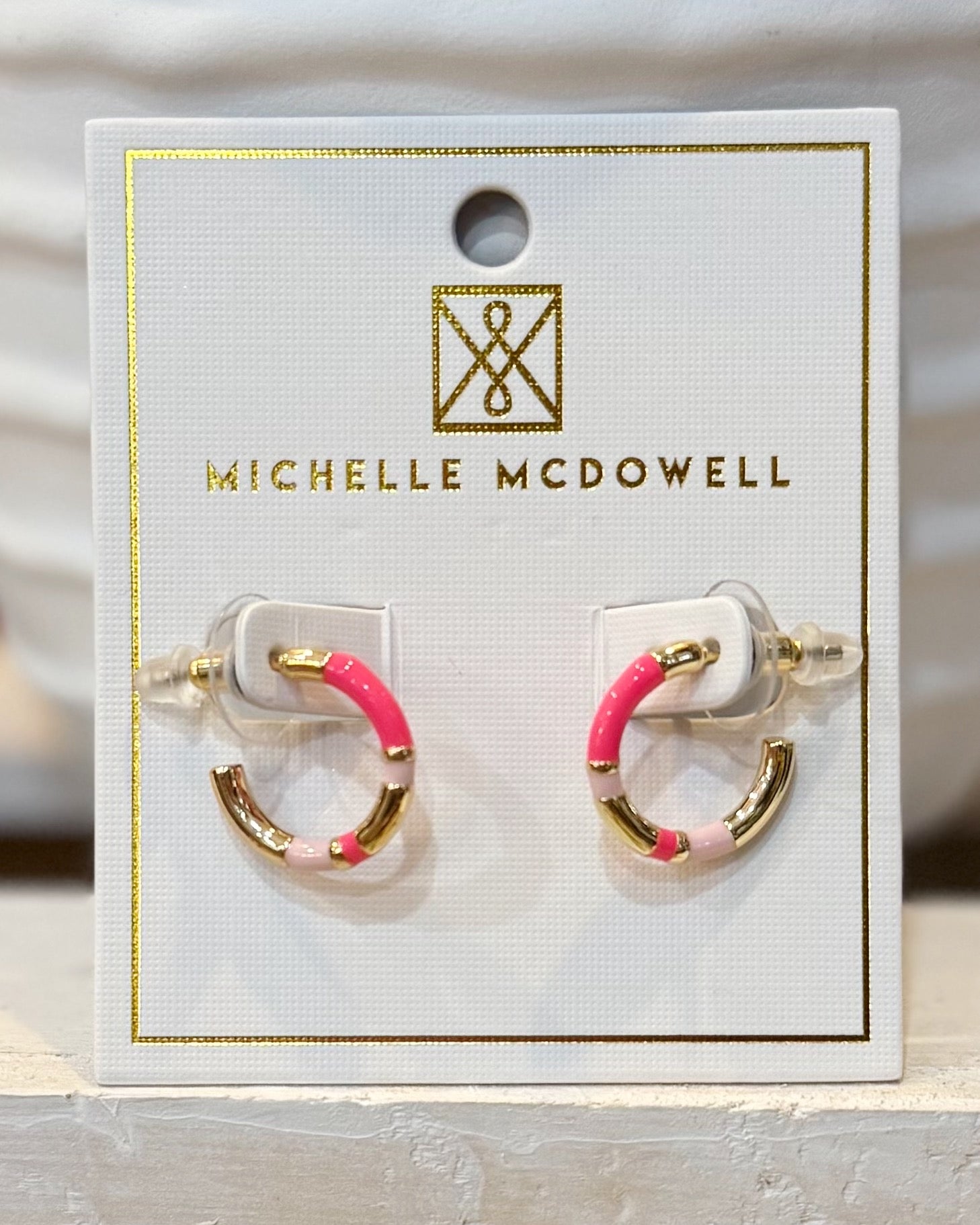 Pair of earrings on a Michelle McDowell branded card.