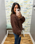 woman wearing a brown crochet sweater cardigan.