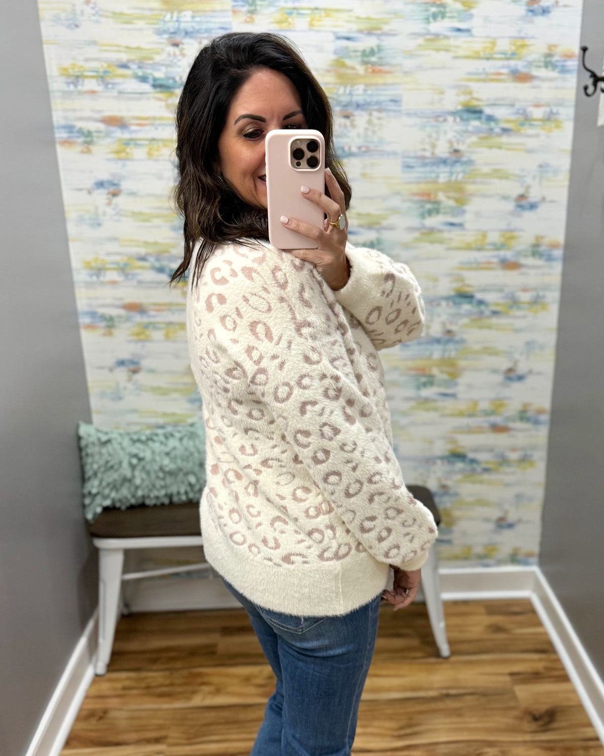 woman taking a selfie wearing a super soft cream sweater with subtle leopard print design. 