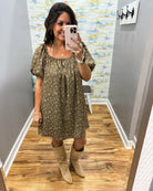 woman taking a selfie wearing a hazelnut mini dress features a beautiful floral print with statement puff sleeves