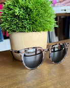 i-sea ella sunglasses sitting on white table.