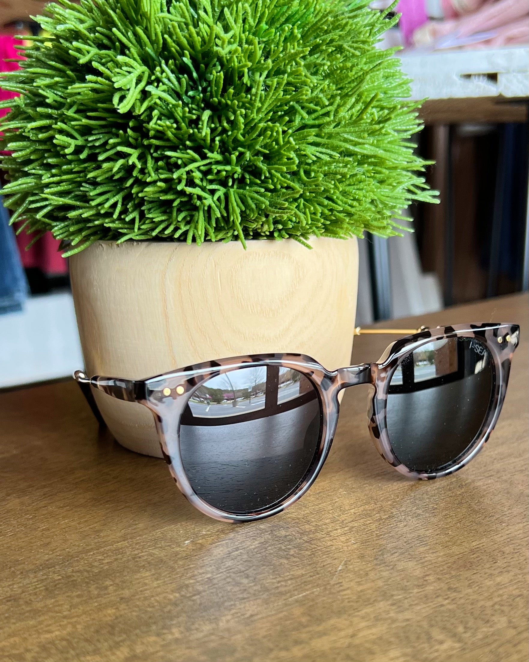 i-sea ella sunglasses sitting on white table.